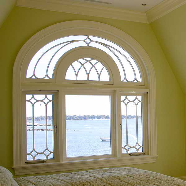 A wooden arched window as an example of a wooden structure of an unusual shape.